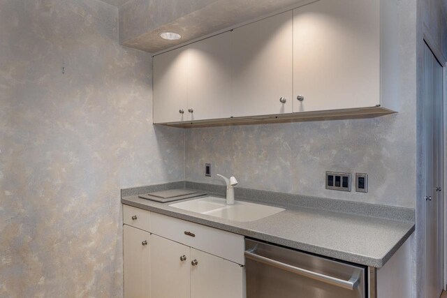 2136 White Swan Dr, Oshkosh, WI 54901 - kitchen with stainless steel dishwasher, light countertops, white cabinetry, and a sink