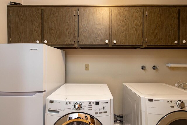 2136 White Swan Dr, Oshkosh, WI 54901 - clothes washing area with separate washer and dryer and cabinet space