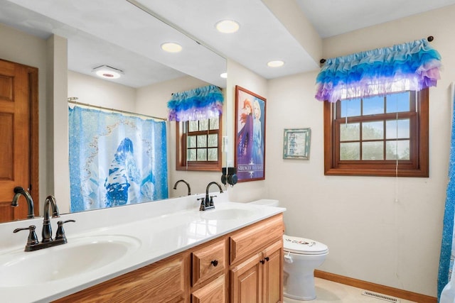 911 Chalfont Dr, Sun Prairie, WI 53590 - bathroom featuring a sink, toilet, and a healthy amount of sunlight