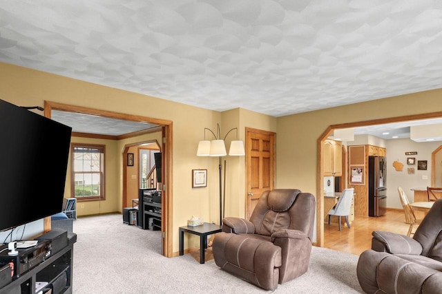 911 Chalfont Dr, Sun Prairie, WI 53590 - living area featuring arched walkways, baseboards, and light colored carpet