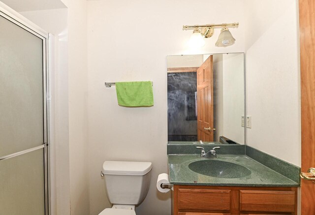 2421 Dover Ln, Mount Pleasant, WI 53406 - bathroom featuring toilet, vanity, and a shower with door