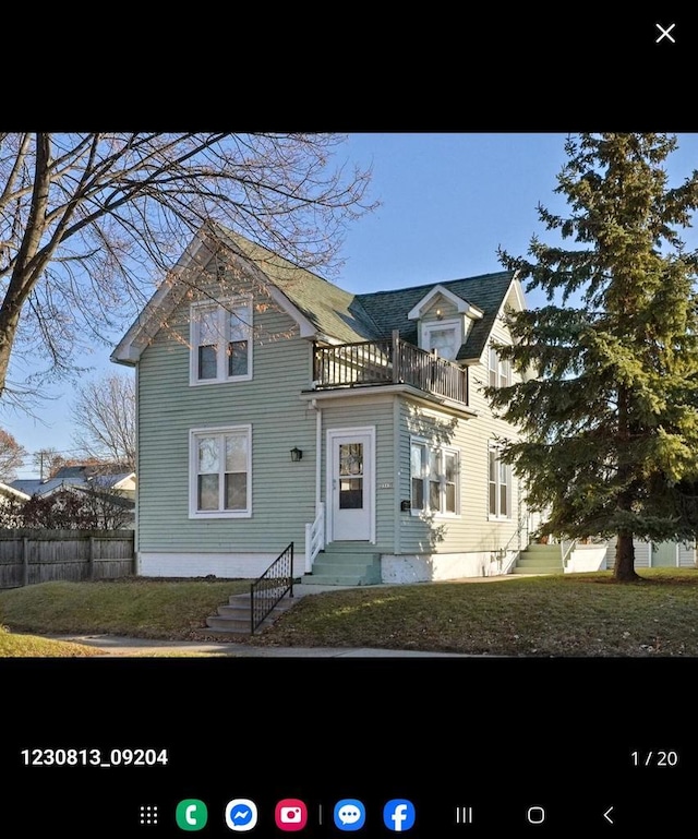 2317 S 9th St, Sheboygan, WI 53081 - victorian-style house with a front yard, a balcony, entry steps, and fence