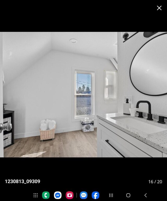 2317 S 9th St, Sheboygan, WI 53081 - bathroom featuring wood finished floors, vanity, and vaulted ceiling
