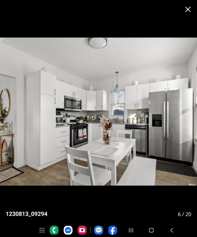 2317 S 9th St, Sheboygan, WI 53081 - kitchen with tasteful backsplash, white cabinets, appliances with stainless steel finishes, a sink, and decorative light fixtures