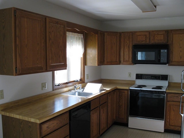 kitchen with light countertops, a sink, black appliances, and brown cabinetry