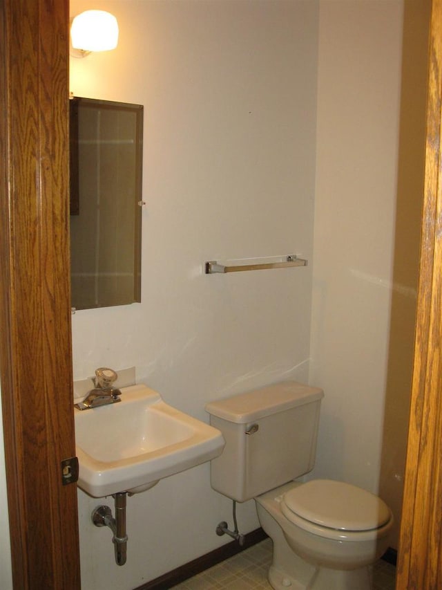 half bathroom featuring toilet and a sink
