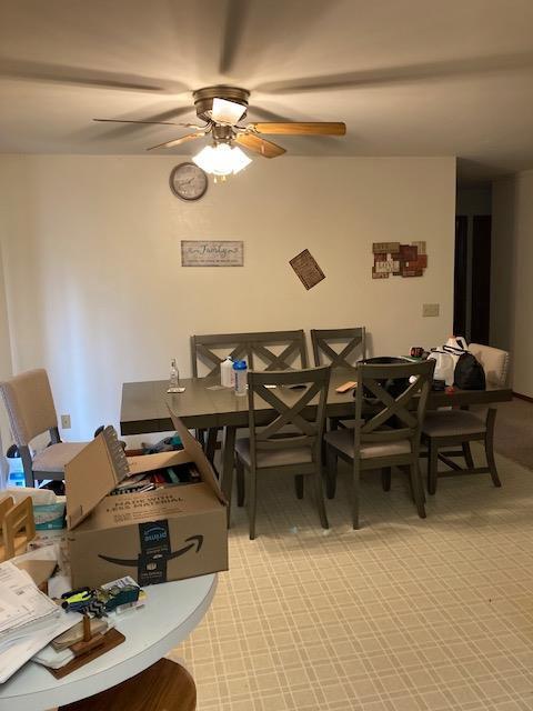 dining area featuring light colored carpet and a ceiling fan
