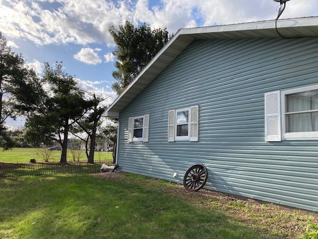 view of side of property with a yard and fence