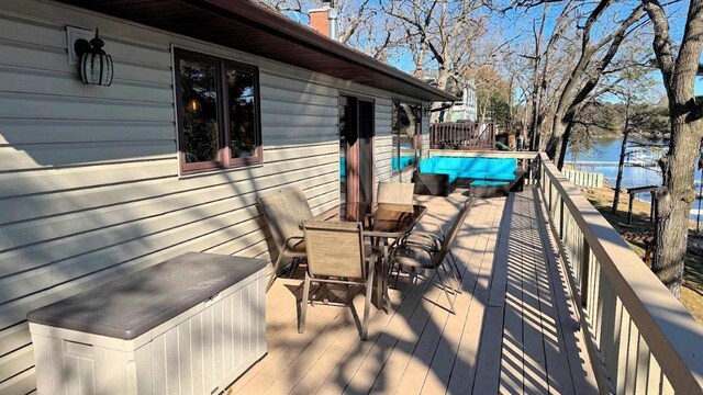 wooden deck featuring outdoor dining space and a water view