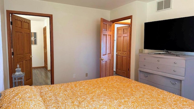 bedroom with wood finished floors and visible vents