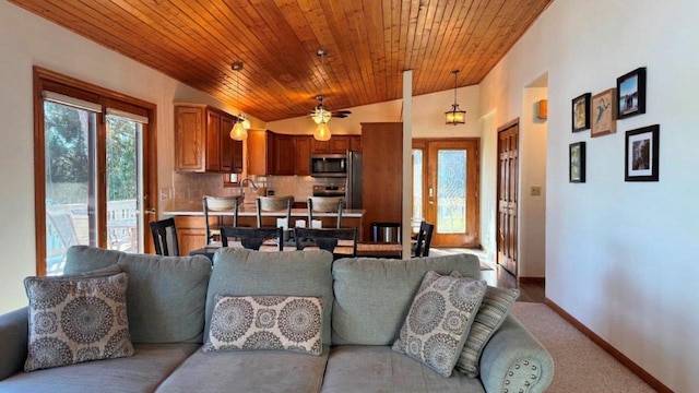 living area featuring lofted ceiling, plenty of natural light, wooden ceiling, and baseboards