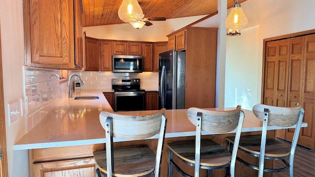 kitchen featuring brown cabinets, stainless steel appliances, backsplash, a sink, and wood ceiling