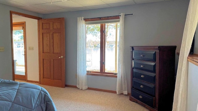 bedroom featuring light carpet and baseboards