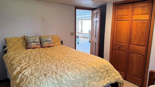 carpeted bedroom with a paneled ceiling