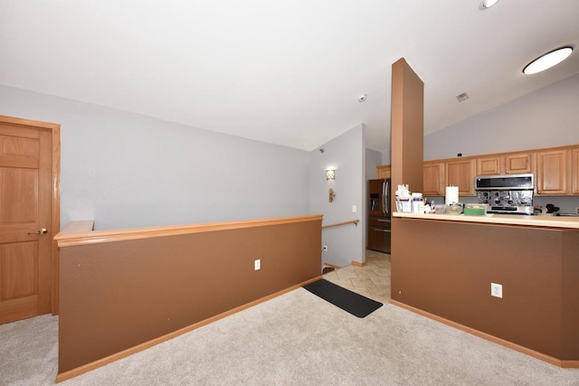 kitchen featuring baseboards, vaulted ceiling, light carpet, visible vents, and stainless steel appliances
