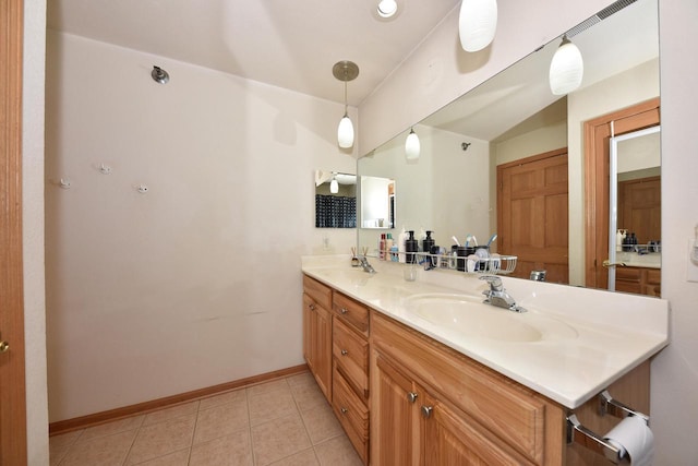 bathroom featuring a sink, tile patterned floors, double vanity, and baseboards