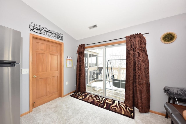 entryway with carpet flooring, visible vents, baseboards, and vaulted ceiling
