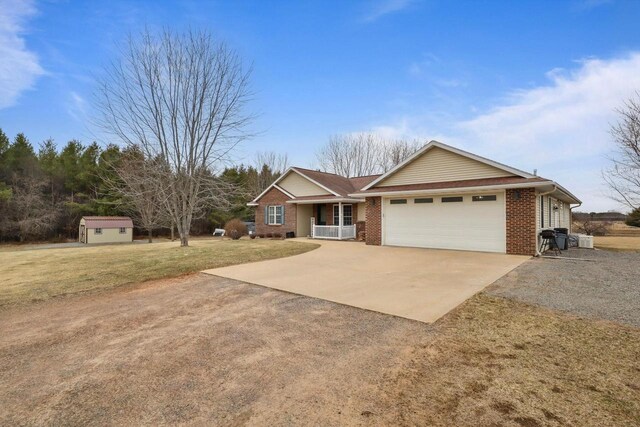 9521 County Road Ww, Wisconsin Rapids, WI 54494 - ranch-style house with a garage, concrete driveway, a storage unit, brick siding, and a front lawn