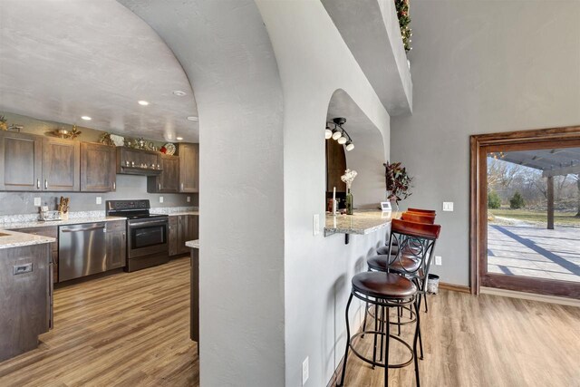 1545 County Rd I, Oshkosh, WI 54902 - kitchen with a kitchen breakfast bar, baseboards, light stone countertops, appliances with stainless steel finishes, and light wood finished floors