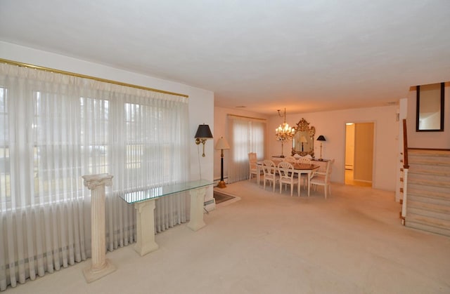 carpeted dining room featuring a notable chandelier and stairs