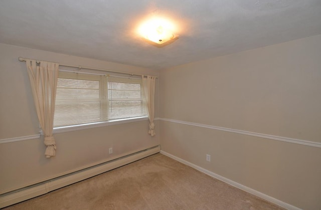 spare room featuring light carpet, a baseboard heating unit, and baseboards