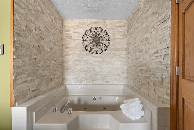 full bath featuring a textured ceiling and a tub with jets