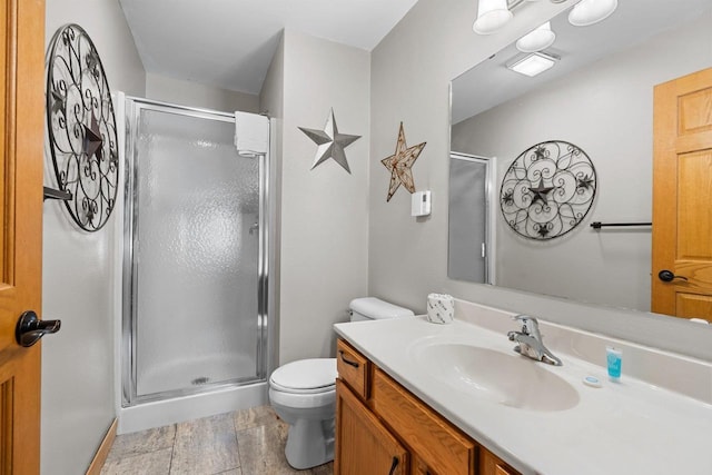 bathroom featuring a shower stall, vanity, and toilet