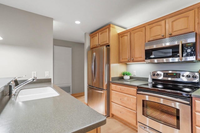 123 W Washington Ave Unit 306, Madison, WI 53703 - kitchen with appliances with stainless steel finishes, a sink, light wood-style flooring, and recessed lighting