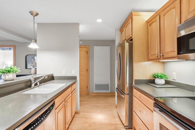 123 W Washington Ave Unit 306, Madison, WI 53703 - kitchen featuring a sink, stainless steel appliances, light brown cabinetry, light wood finished floors, and decorative light fixtures