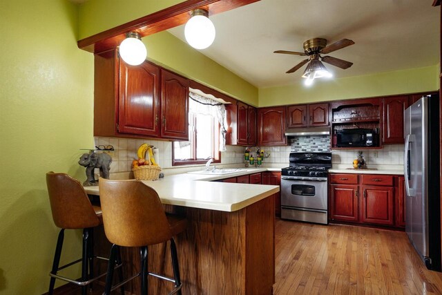 1001 Wisconsin Ave, North Fond Du Lac, WI 54937 - kitchen with tasteful backsplash, a peninsula, dark brown cabinets, a sink, and stainless steel appliances