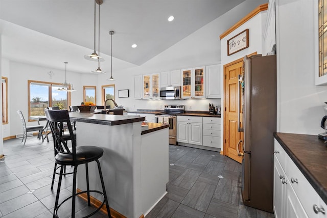 1495 Cattail Ln, Fond Du Lac, WI 54937 - kitchen featuring a breakfast bar, glass insert cabinets, white cabinets, lofted ceiling, and appliances with stainless steel finishes