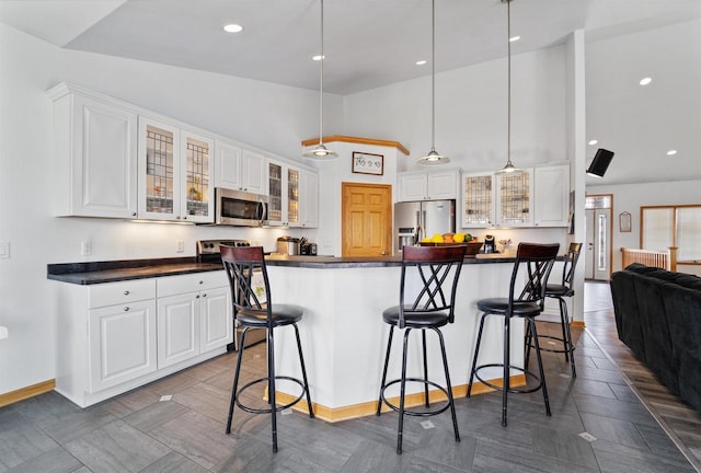 1495 Cattail Ln, Fond Du Lac, WI 54937 - kitchen with stainless steel appliances, a kitchen breakfast bar, and dark countertops