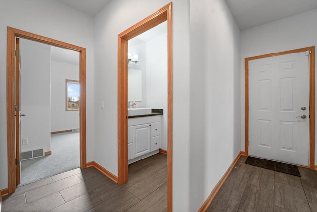 1495 Cattail Ln, Fond Du Lac, WI 54937 - hall featuring a sink, visible vents, baseboards, and wood finished floors