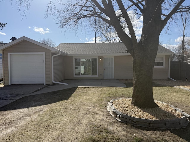 ranch-style home featuring a shingled roof, a front yard, and a garage