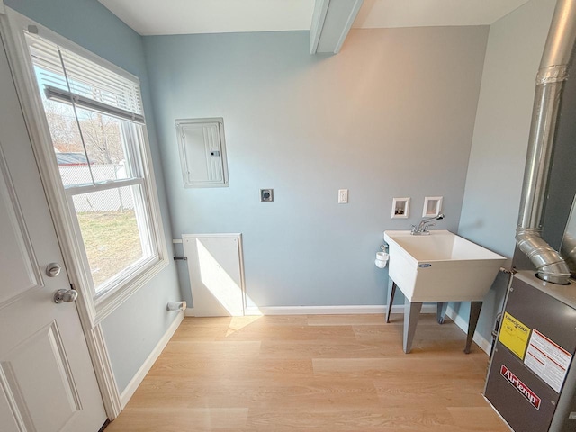 clothes washing area with plenty of natural light, hookup for an electric dryer, electric panel, light wood finished floors, and washer hookup