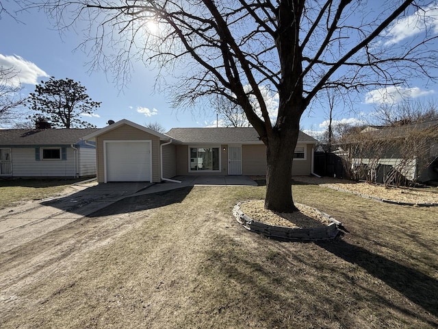 single story home with driveway, fence, and a garage