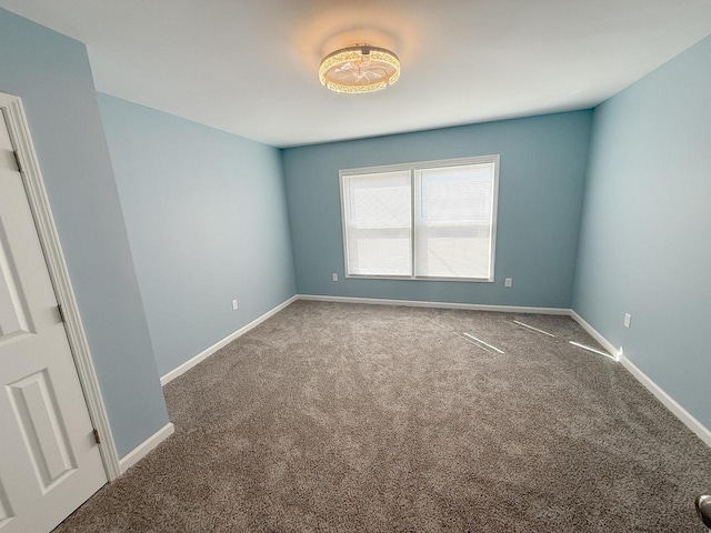 carpeted empty room with baseboards