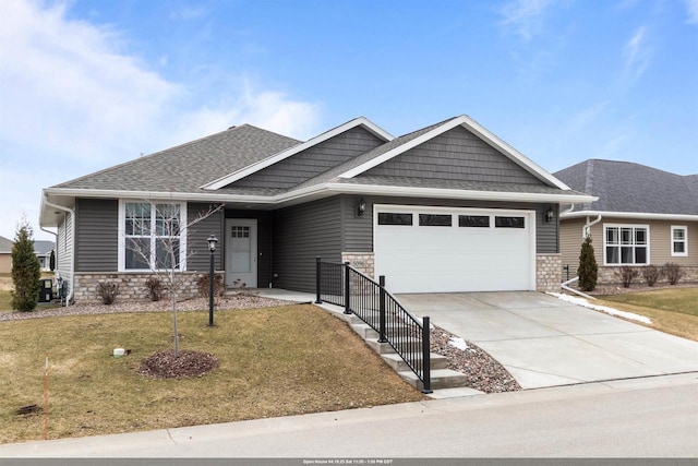5096 N Milkweed Trl, Appleton, WI 54913 - craftsman house featuring roof with shingles, a front yard, stone siding, an attached garage, and driveway