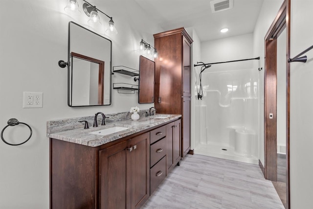 5096 N Milkweed Trl, Appleton, WI 54913 - full bath featuring a shower, visible vents, a sink, and wood finished floors