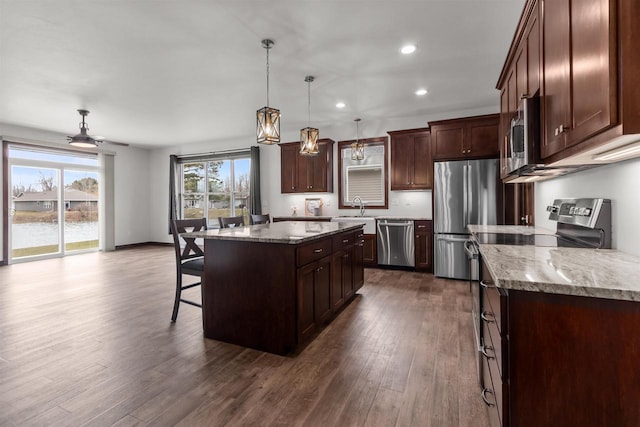 5096 N Milkweed Trl, Appleton, WI 54913 - kitchen with dark wood finished floors, stone counters, a center island, stainless steel appliances, and a breakfast bar area