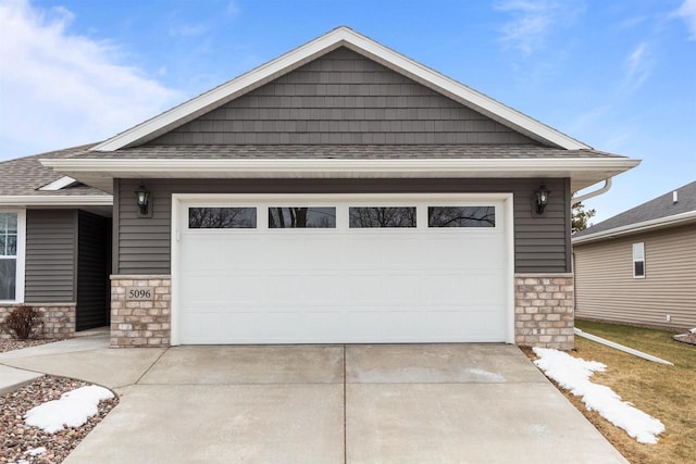 5096 N Milkweed Trl, Appleton, WI 54913 - view of front of house featuring an attached garage, a shingled roof, stone siding, and concrete driveway