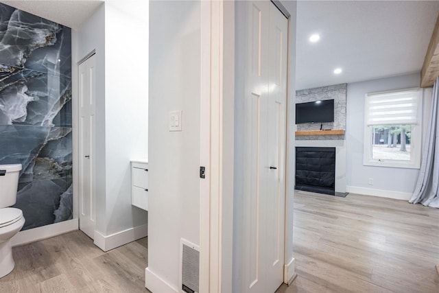 hallway with visible vents, baseboards, recessed lighting, and wood finished floors