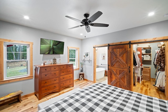 1979 9th Ave, Friendship, WI 53934 - bedroom featuring a barn door, recessed lighting, light wood-style flooring, and multiple windows