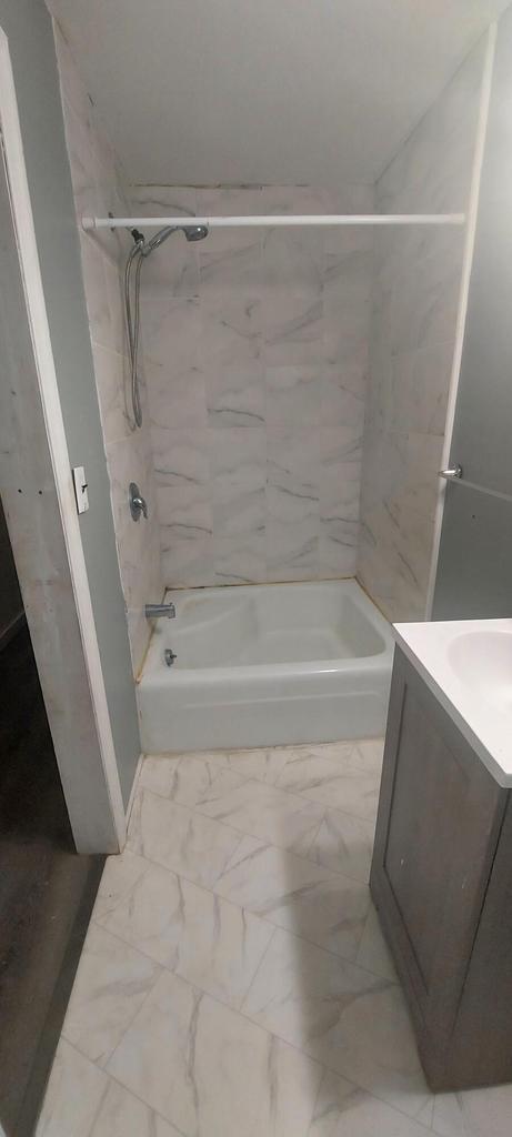 140 E Ave, Iron Ridge, WI 53035 - bathroom featuring vanity, shower / tub combination, and marble finish floor