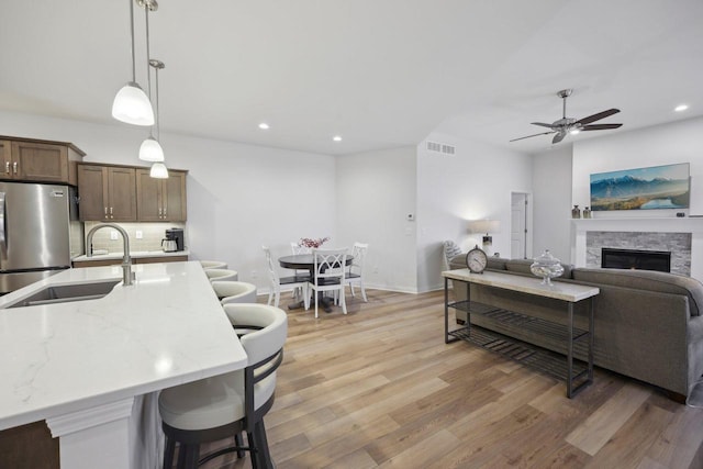 living area featuring light wood-type flooring, a ceiling fan, visible vents, and recessed lighting
