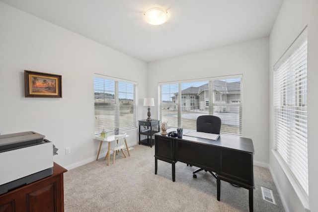 office featuring visible vents, light colored carpet, and baseboards