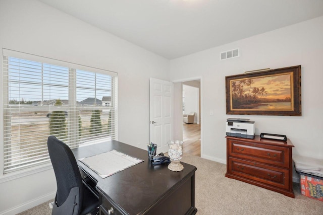 carpeted office with visible vents and baseboards