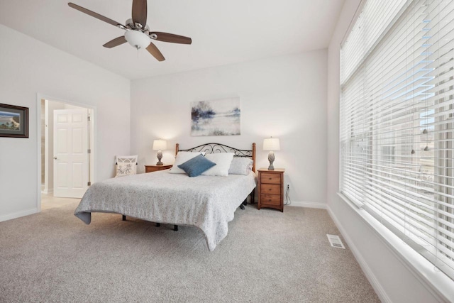 bedroom with visible vents, multiple windows, and light carpet