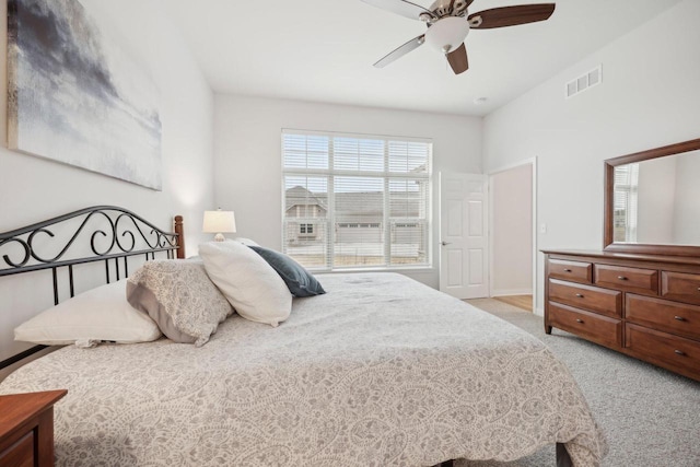 bedroom with visible vents, baseboards, a ceiling fan, and light colored carpet