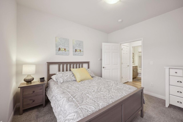 carpeted bedroom with baseboards and connected bathroom